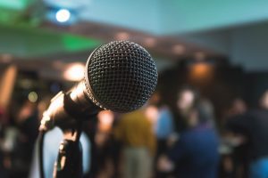 A microphone in front of a gathering of people.